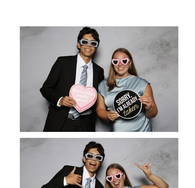 A printed photo strip of two guests posing with heart shaped props